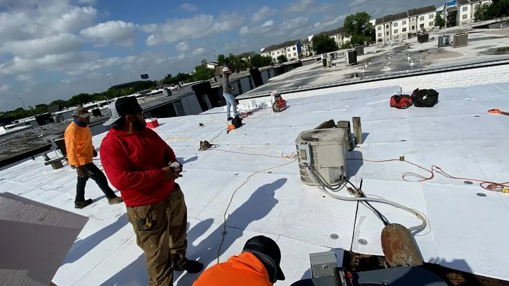 Commercial roofing crew working on flat roof system